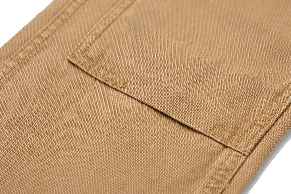 Close-up of a tan canvas fabric product, showing a stitched pocket and detailed weave texture on a white background.