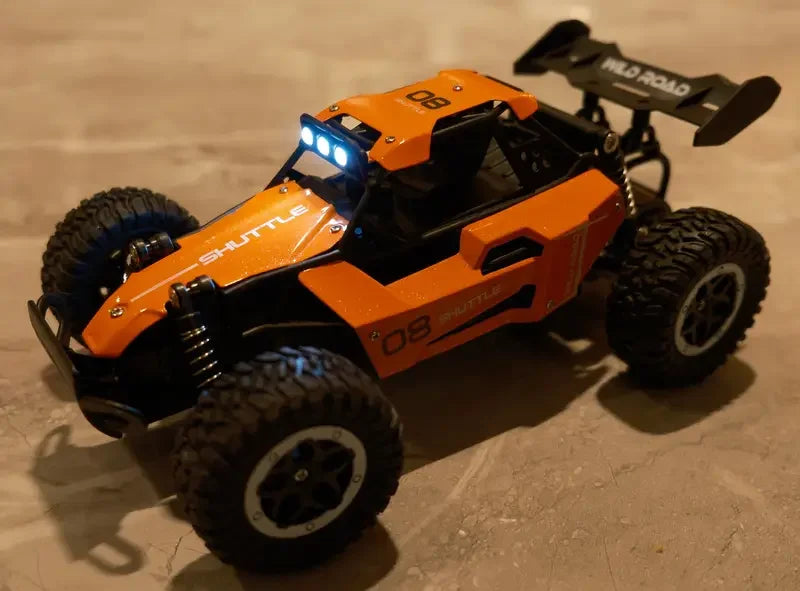 Orange and black remote control car on a concrete surface