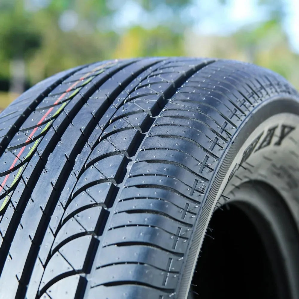 Close-up of a tire with tread pattern and brand name on a blurred natural background