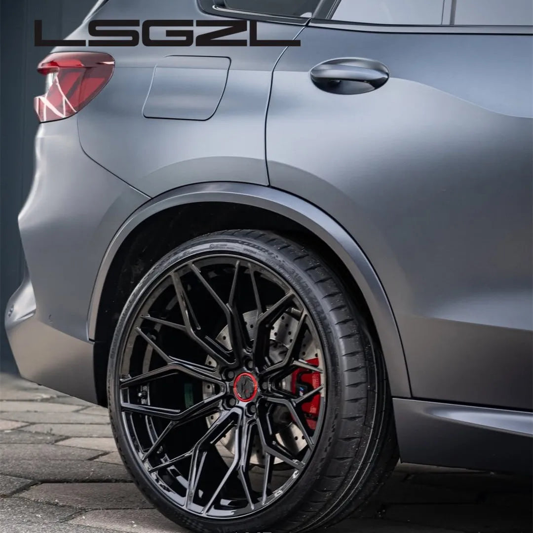 A close-up of a matte black multi-spoke aftermarket car wheel installed on a dark gray SUV, showing the wheel, tire, brake caliper, and part of the vehicle body. The brand name 'LSGZL' is printed in white at the top left.