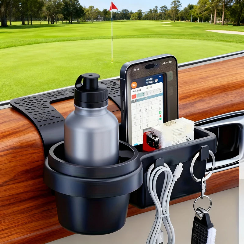 A black car dashboard organizer mounted on a wood-grain console, holding a silver water bottle in a cup holder, a smartphone in a stand, and accessories in side pockets. A golf course scene is visible through the windshield.