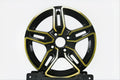 A multi-spoke alloy wheel rim in glossy black with polished gold accents, displayed on a black stand against a light gray background.