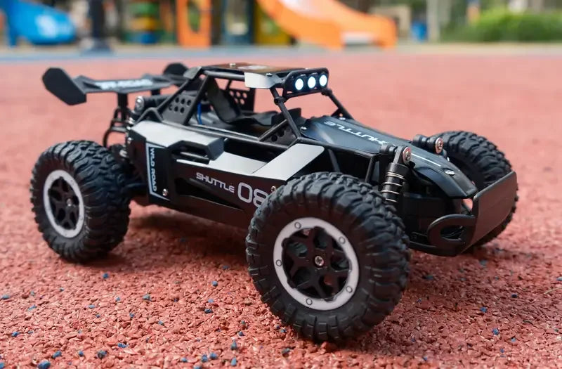 Black remote control car on a red surface with playground equipment in the background