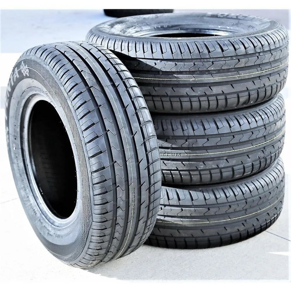 Four black car tires, with three stacked and one leaning in front, showing detailed tread patterns on a light gray concrete surface.