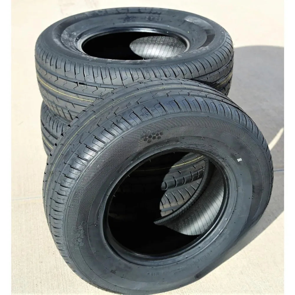 Three black rubber tires stacked and leaning on a light concrete surface, showing the tread and sidewall details.