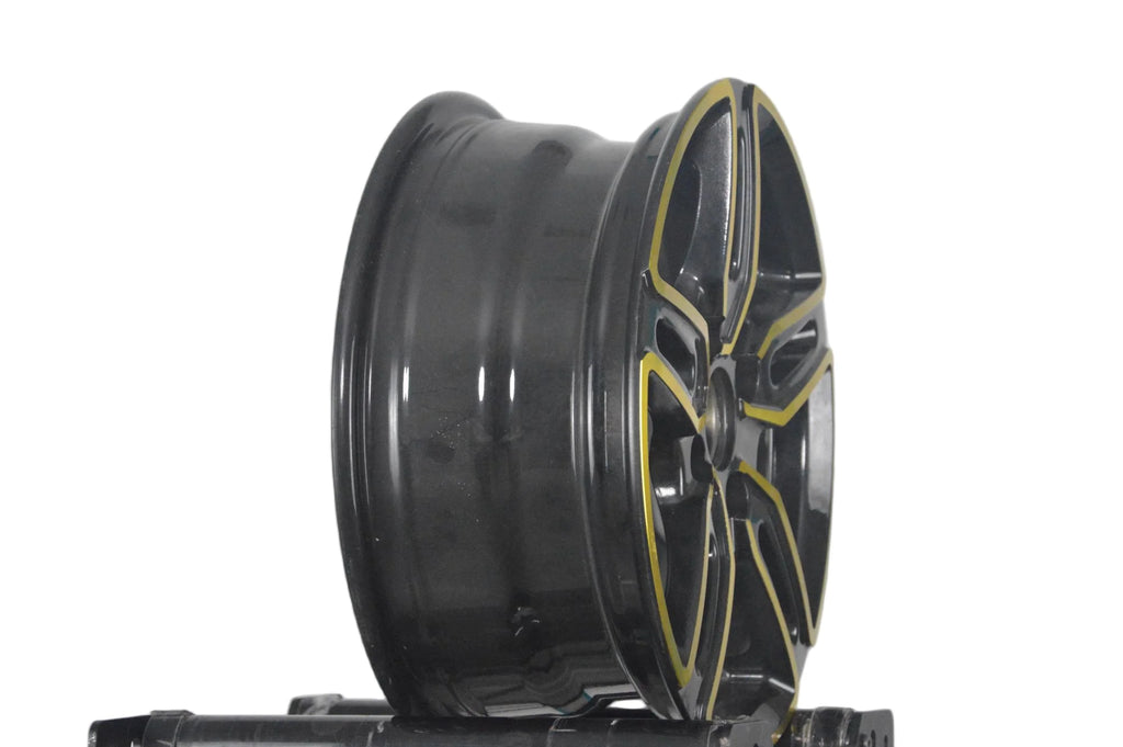 A black multi-spoke alloy wheel rim with gold accents, shown from a side angle on a white background.