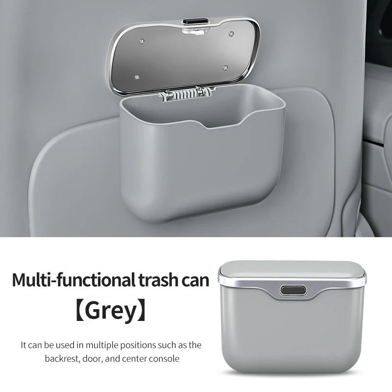 Multi-functional trash can in gray color with lid open inside a car.