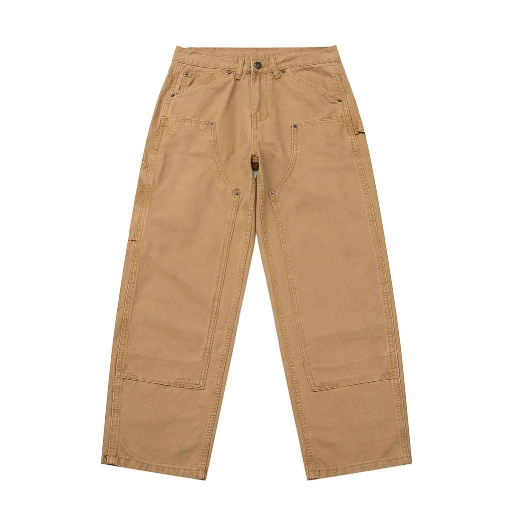 A pair of tan canvas work pants with multiple utility pockets, laid flat against a solid white background.