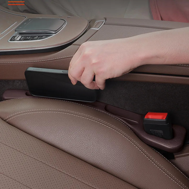 Hand placing a phone on a car seat armrest with Chinese text about driving safety.