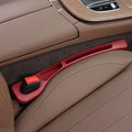 Car interior with a red door handle and brown leather seats.