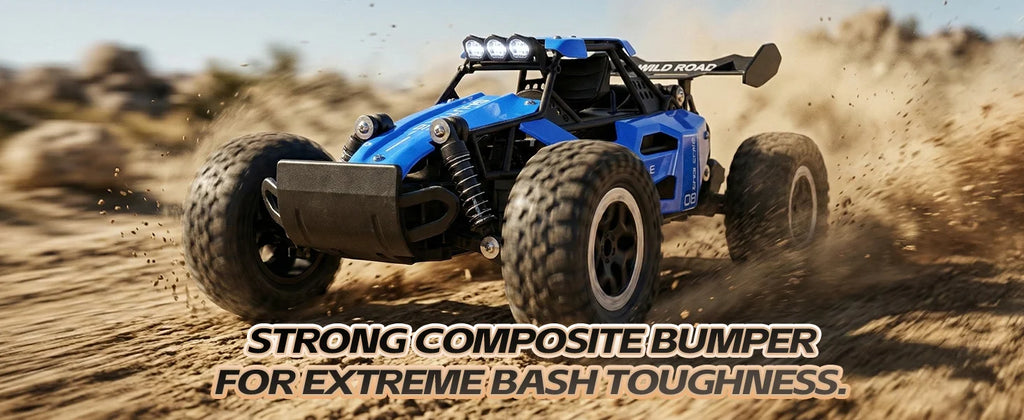 A blue and black remote control off-road buggy driving on a sandy desert track, kicking up dust. Text overlay at the bottom reads 'STRONG COMPOSITE BUMPER FOR EXTREME BASH TOUGHNESS.