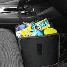 A black car seat organizer bag filled with various household items, shown installed on a gray car seat next to the steering wheel.